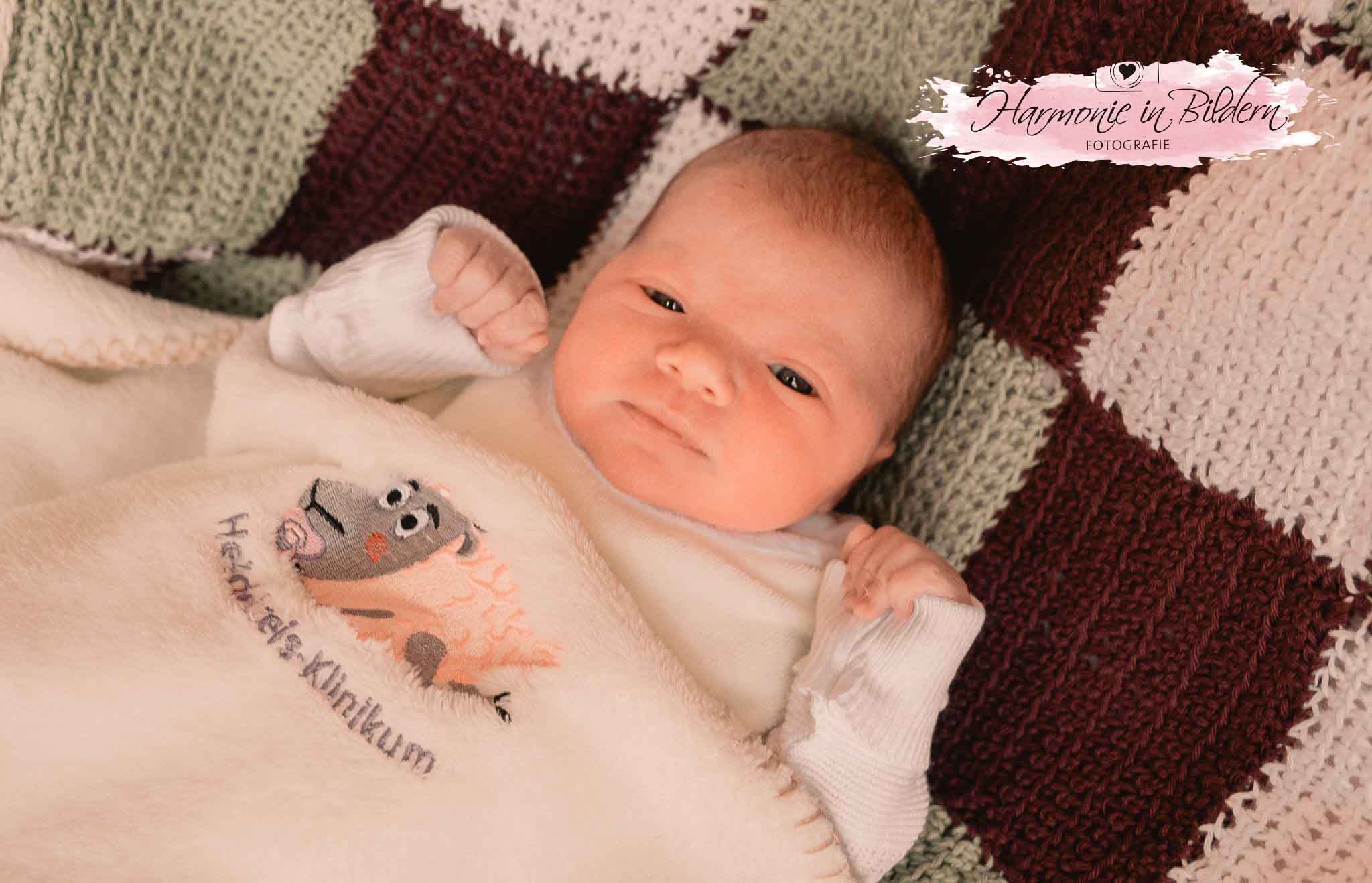 Foto eines Neugeborenen auf einer Babydecke.