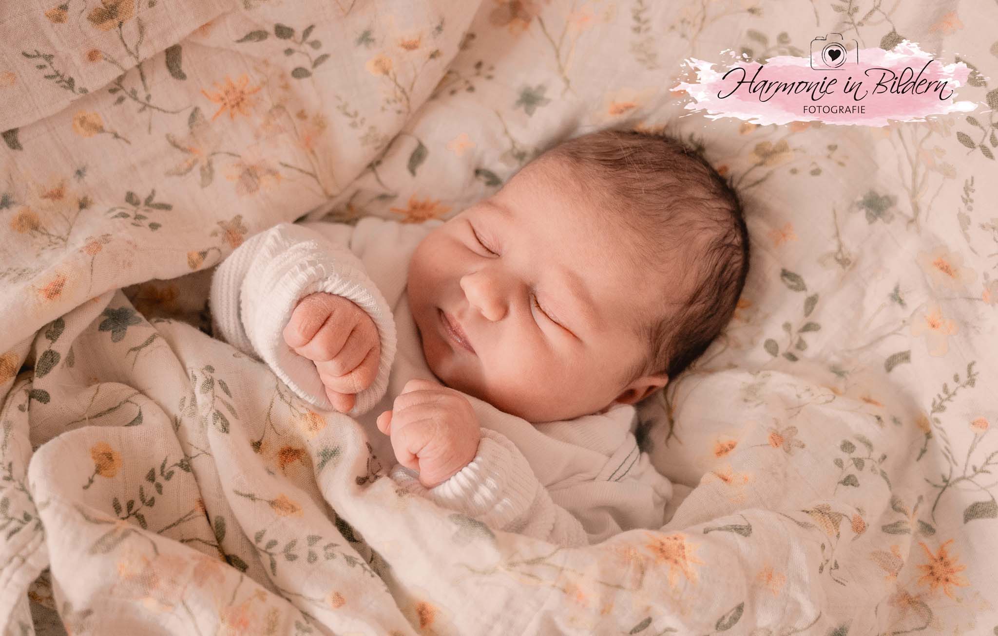 Foto eines Neugeborenen auf einer Babydecke.