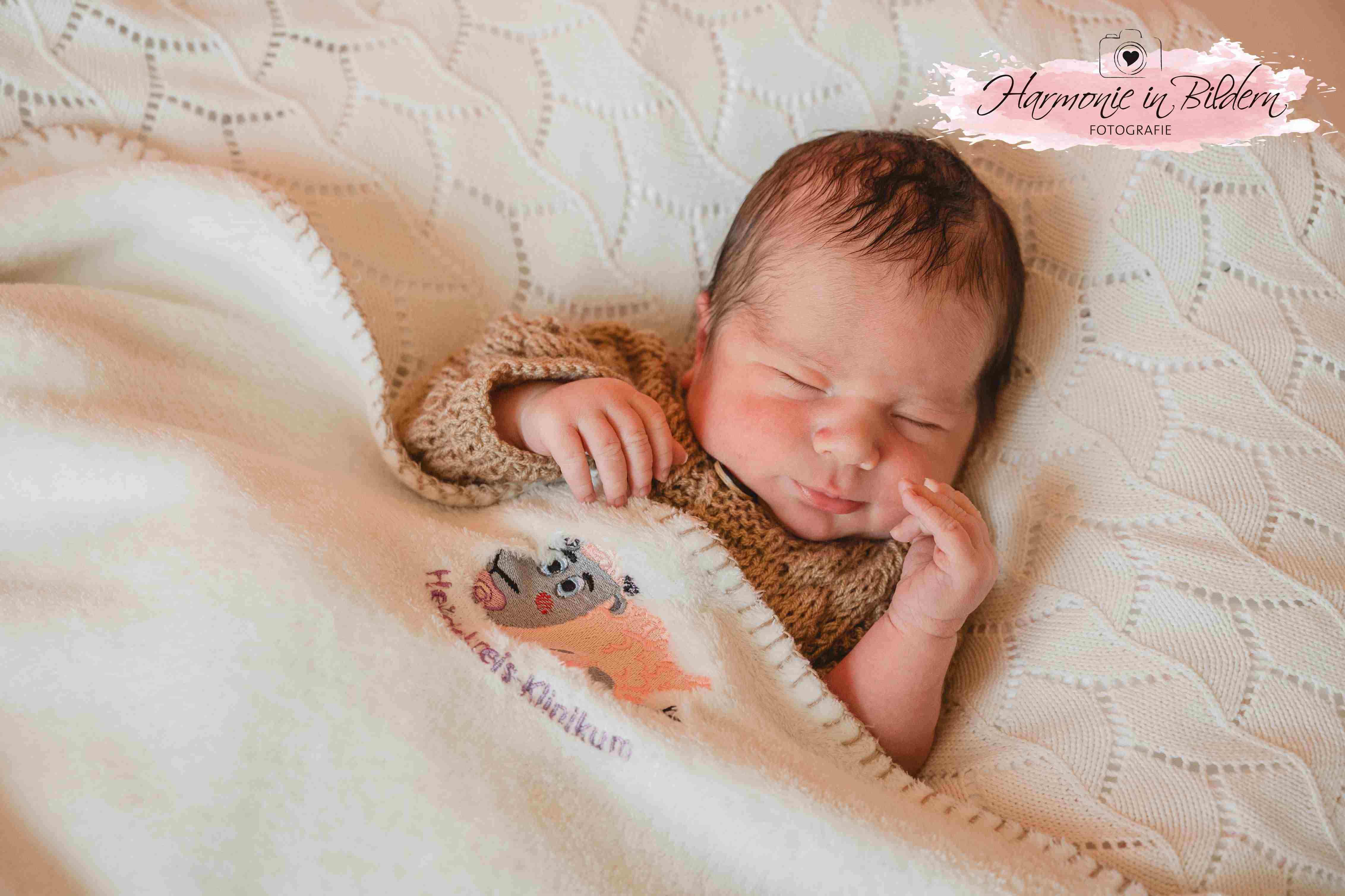 Foto eines Neugeborenen auf einer Babydecke.
