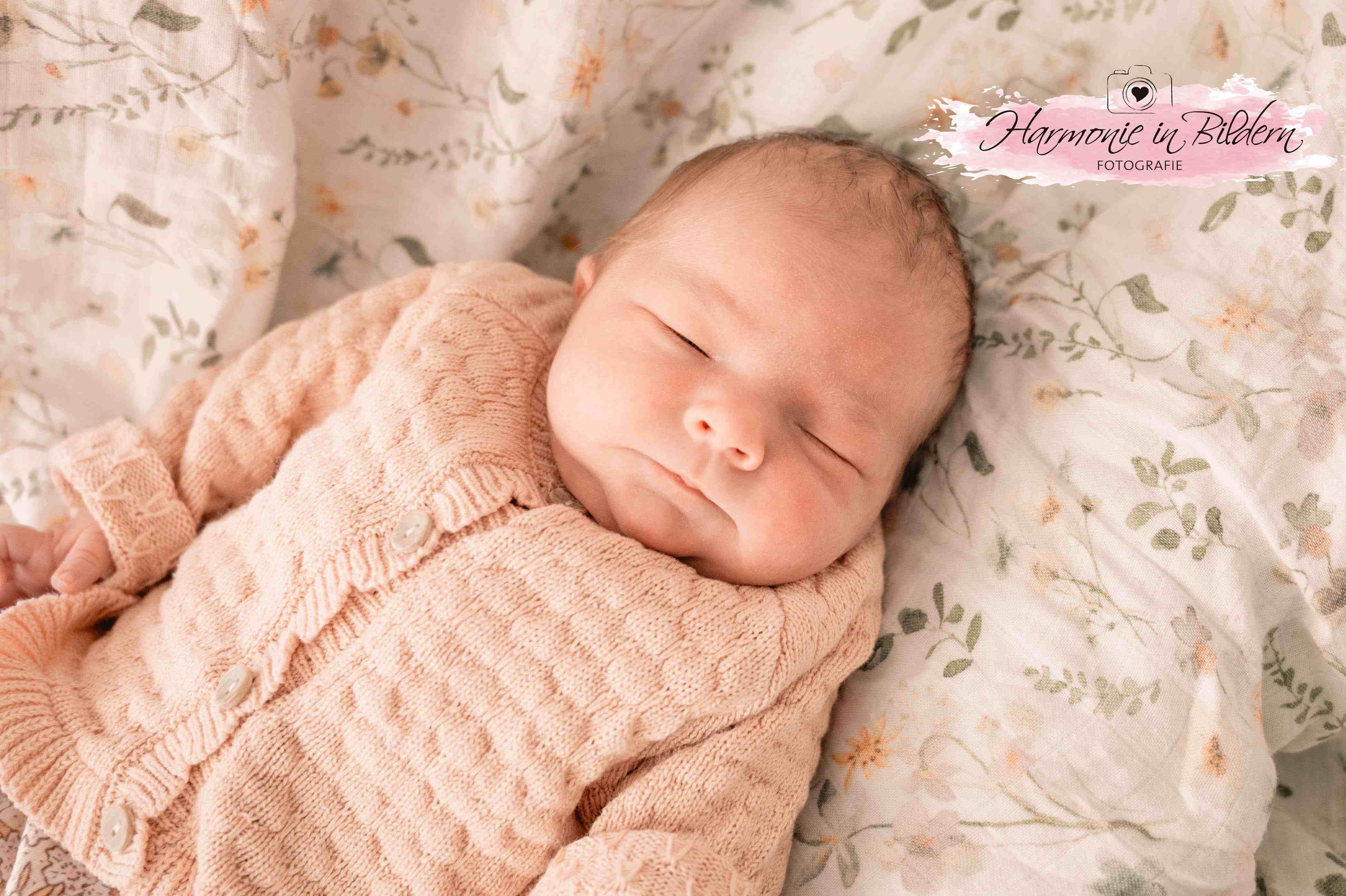 Ein Baby liegt auf einer Babydecke. Es schläft.