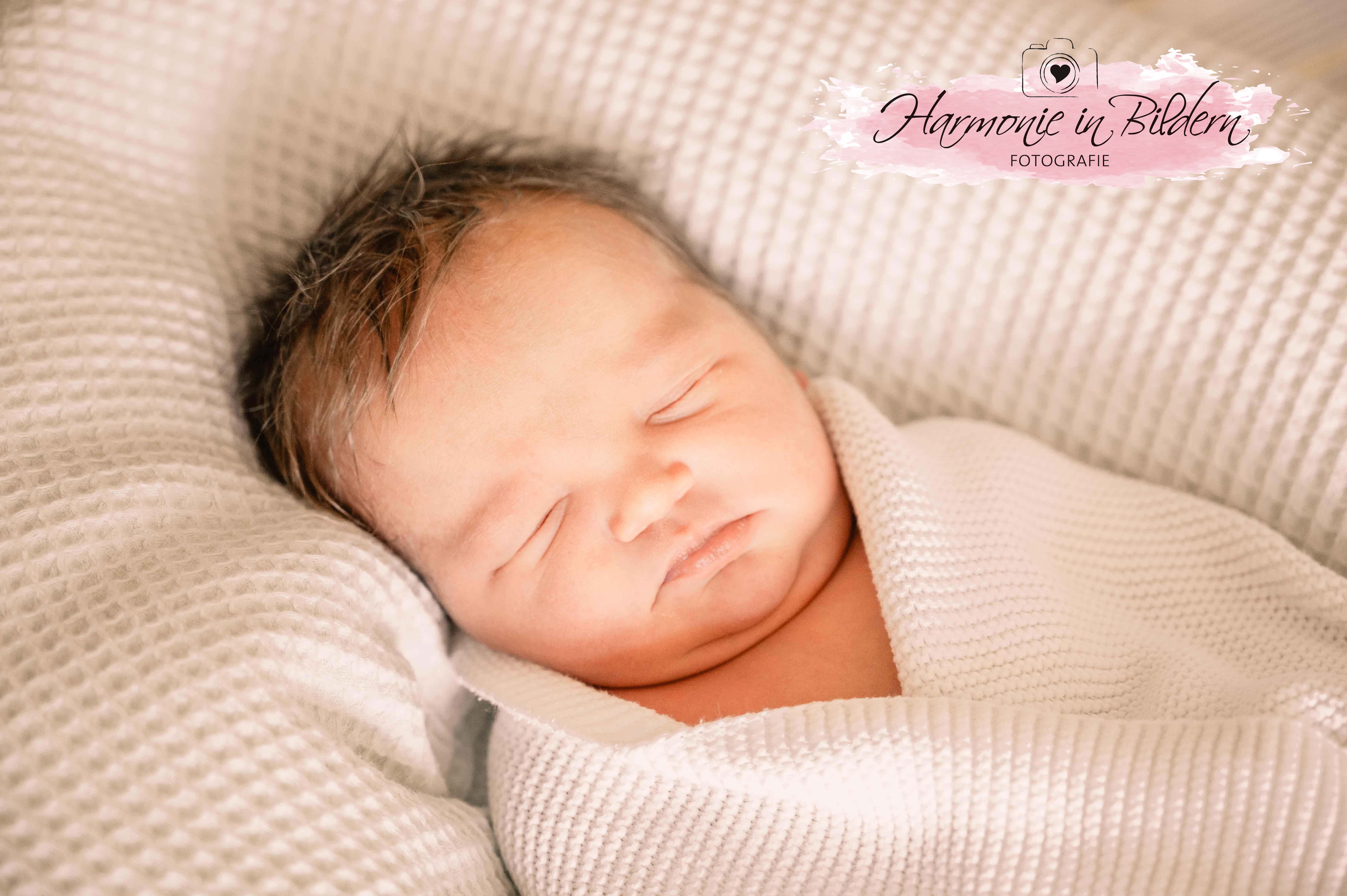 Foto eines Neugeborenen auf einer Babydecke.