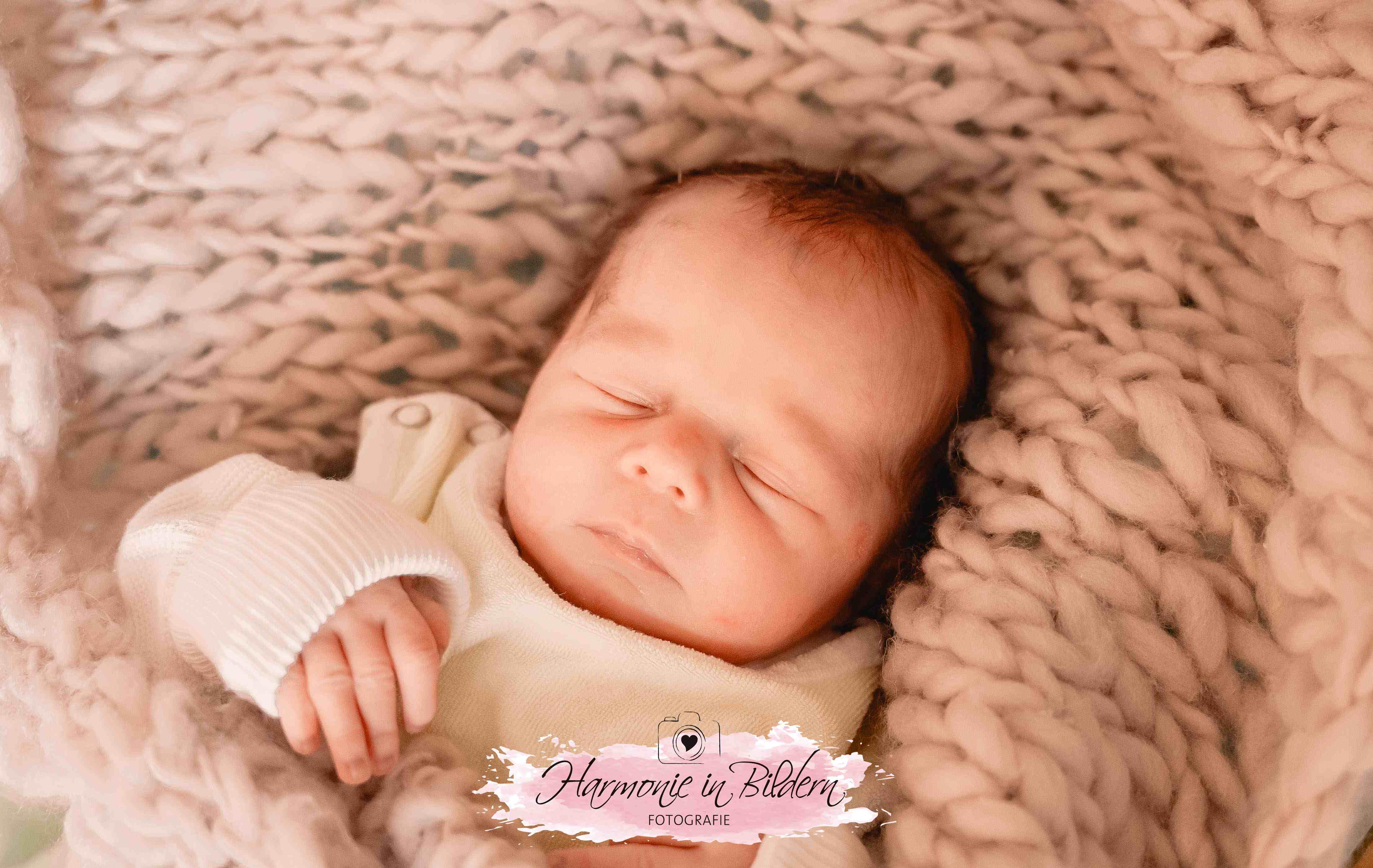 Ein Baby auf einer  Decke im Babybett