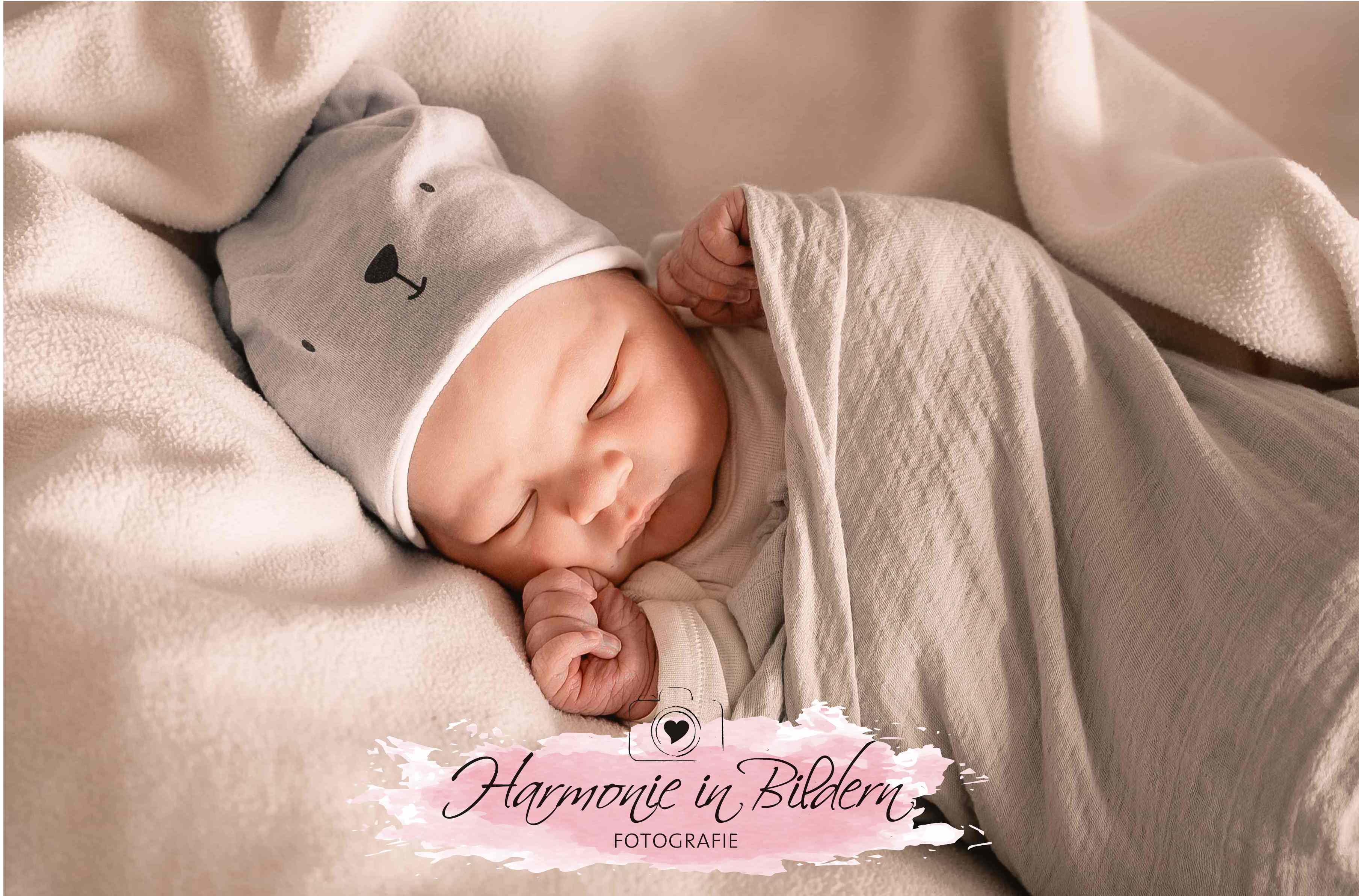 Neugeborener Junge mit blauer Mütze , schläft