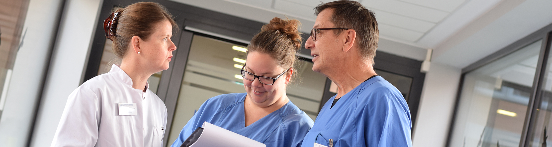 Eine Ärztin der Kardiologie im Gespräch mit Pflegekräften.