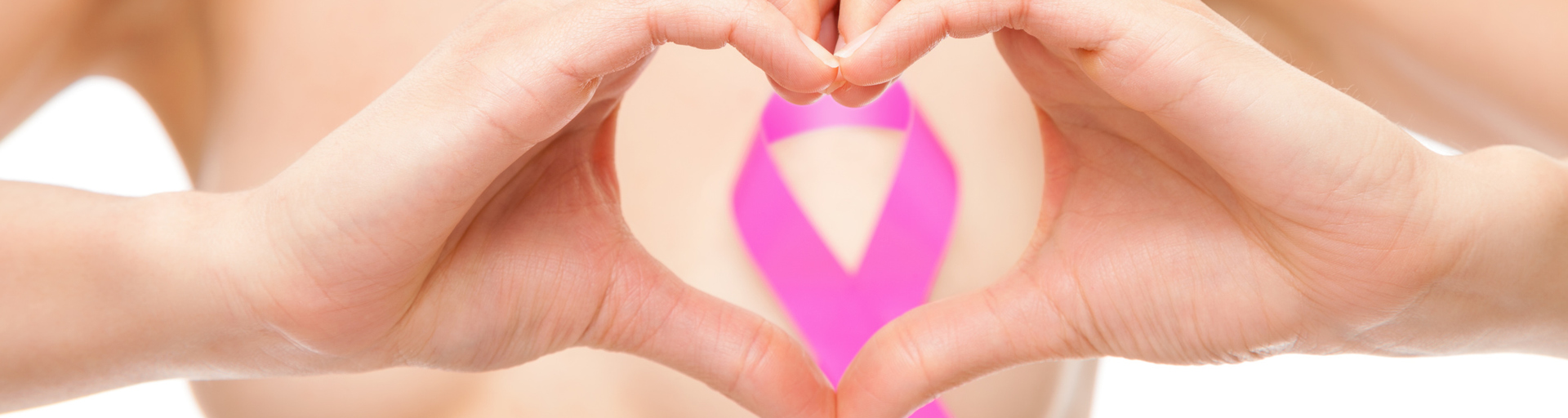 Eine pinke Schleife auf der Brust einer Frau.