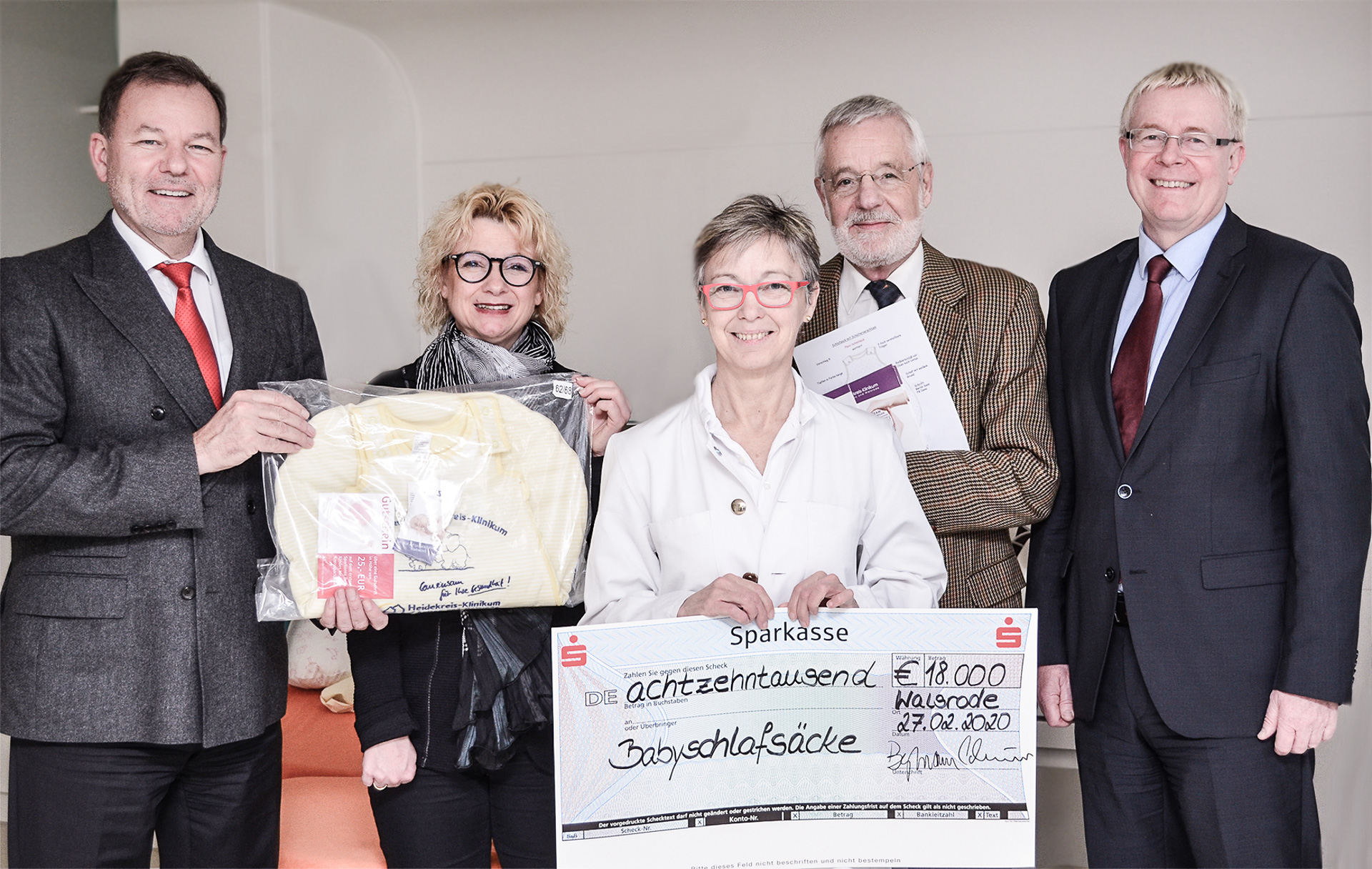 Dr. Thein hält einen großen Spendenscheck in der Hand.