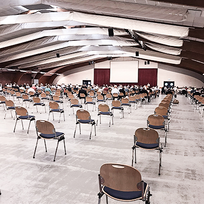 Stühle stehen in einem große leeren Saal.