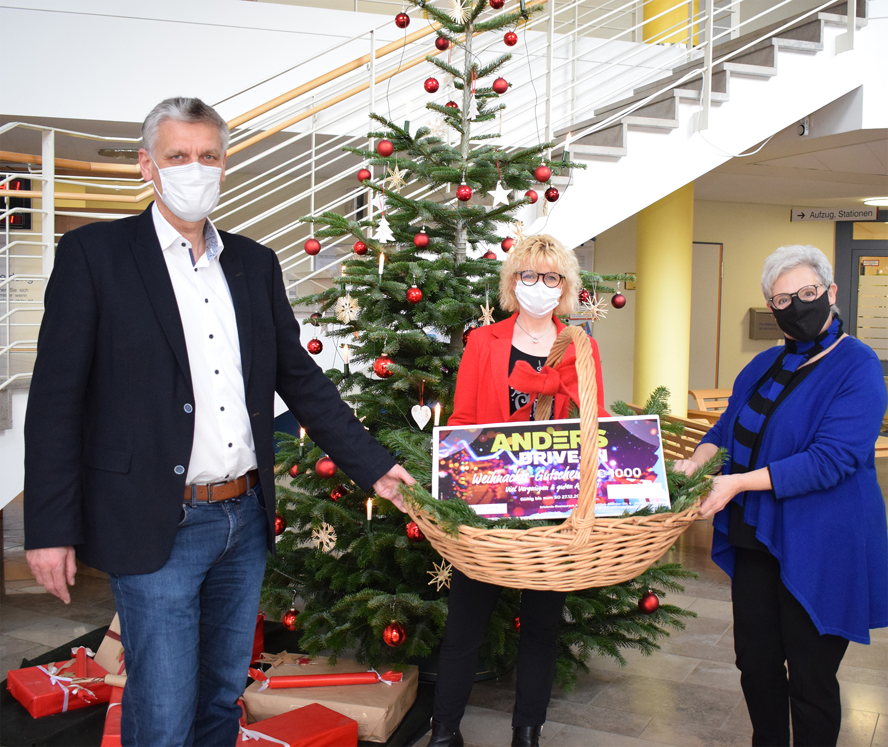 Dr. Rogge steht vor einem Weihnachtsbaum.