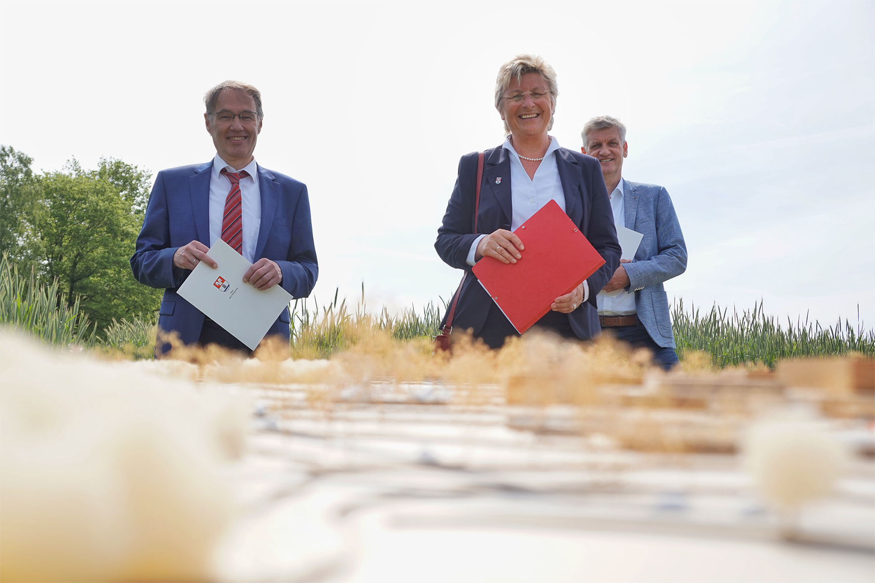 Dr. Rogge und zwei andere Personen steht auf einem Feld.
