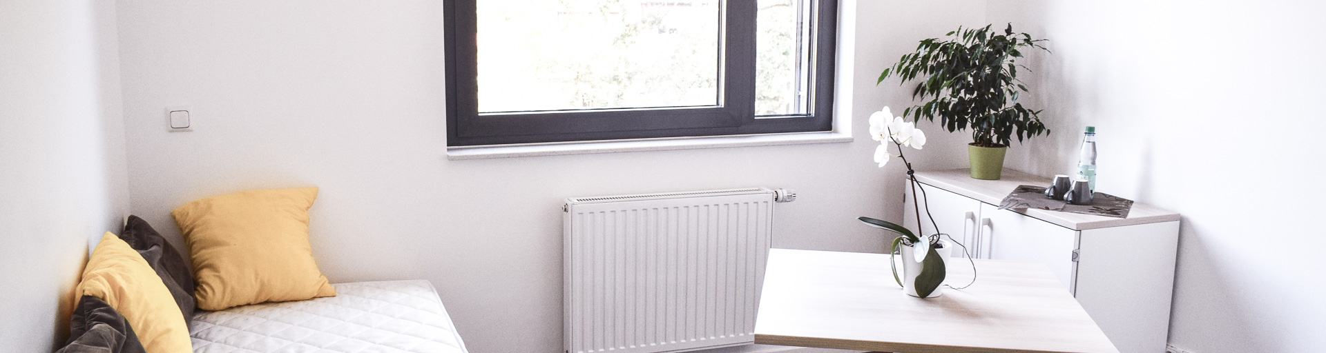 Wohnraumzimmer mit Bett, Tisch und Sideboard