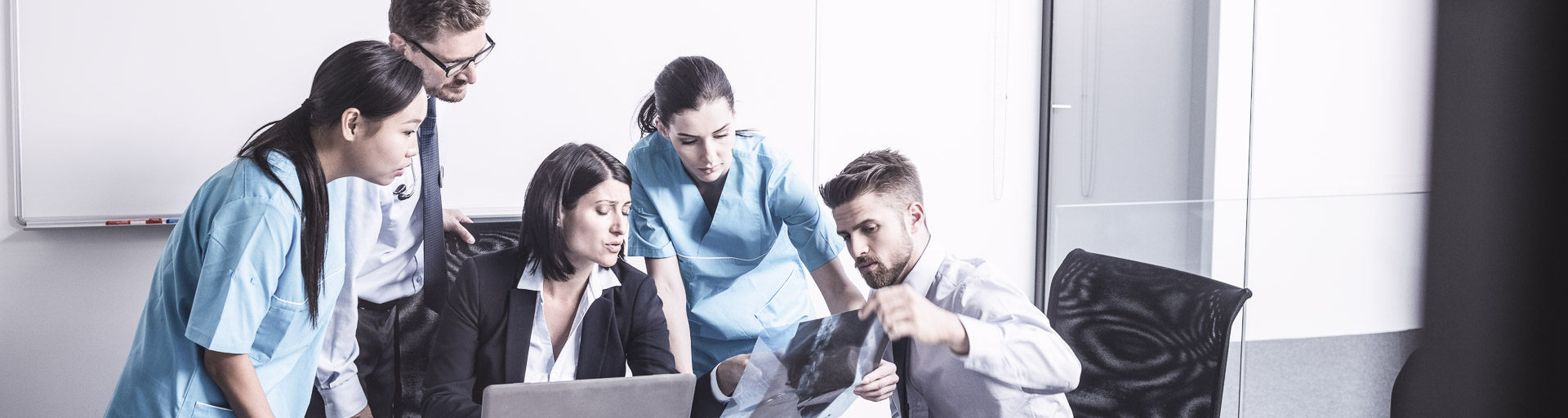 Männer und Frauen diskutieren ein Röntgenbild