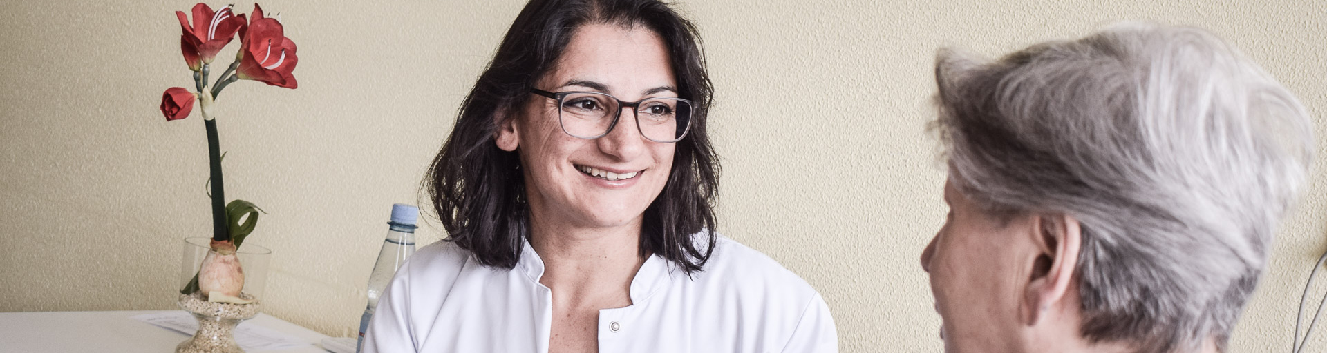 Chefärztin lächelt eine ältere Patientin an