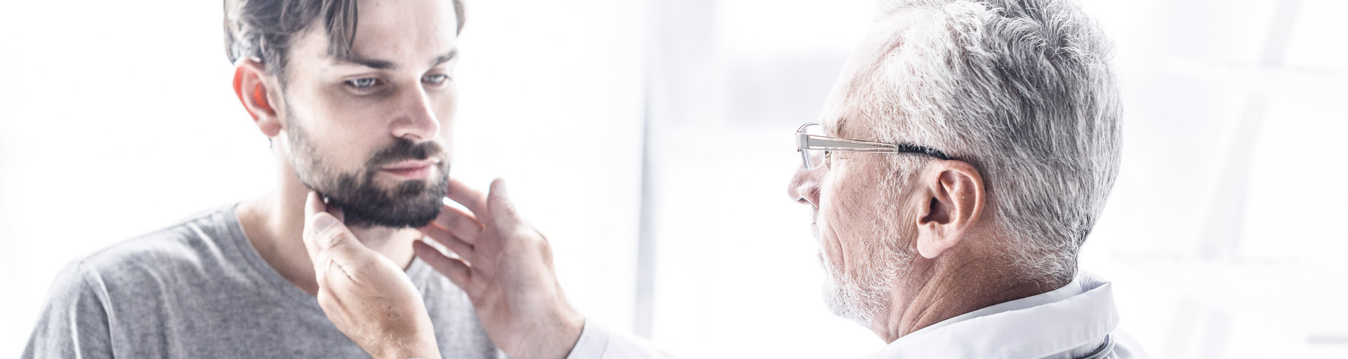Doktor untersucht die Lymphknoten eines Patienten