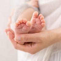 Eine Pflegerin hält ein Baby in den Händen.