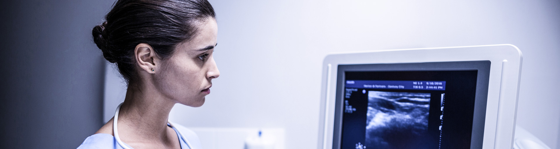 Ärztin schaut auf den Monitor eines Ultraschallgerätes