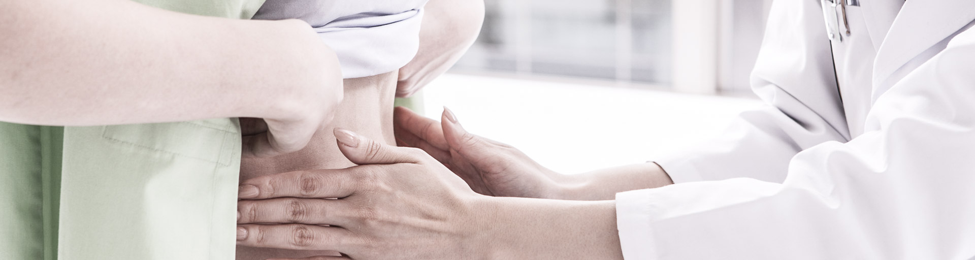 Ärztin tastet den Bauch einer Patientin ab