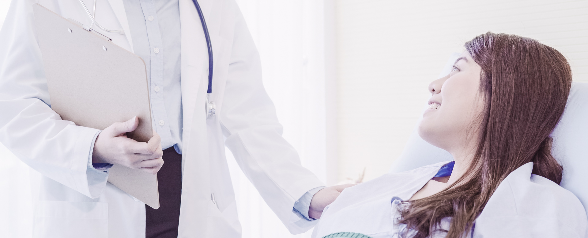 Ärztin legt einer Patienten eine Hand auf die Schulter